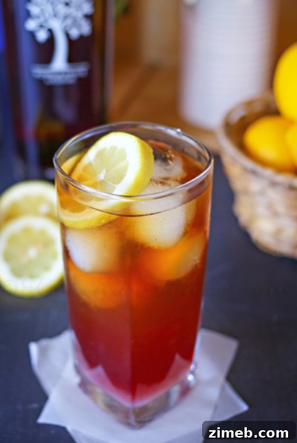 Crimson Chill Hard Tea 3 Two glasses of Pomegranate Hard Iced Tea on a rustic wooden table outdoors