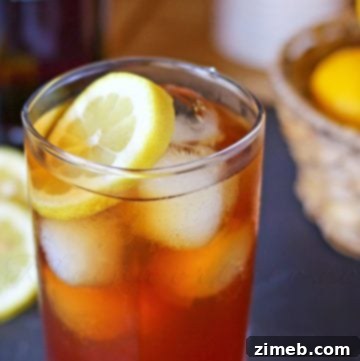 Pomegranate Hard Iced Tea with lemon garnish in a clear glass