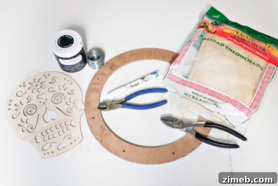Crafting supplies laid out, including a wreath form, corn husks, floral wire, and paints for the sugar skull wreath project