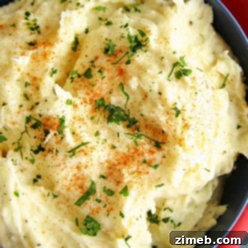 Decadent Garlic Butter Filet Mignon 11 A bowl of creamy garlic mashed potatoes, topped with melted butter and garnished with fresh herbs. The smooth, fluffy texture of the potatoes is highlighted by the rich, buttery sheen, making the dish look warm, comforting, and flavorful. Perfect as a savory side dish for any meal.