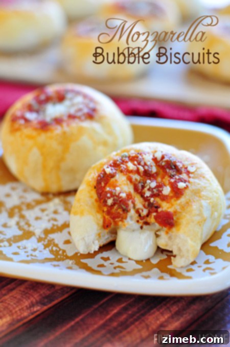 Golden brown Mozzarella Bubble Biscuits pulled apart, revealing gooey melted mozzarella inside.