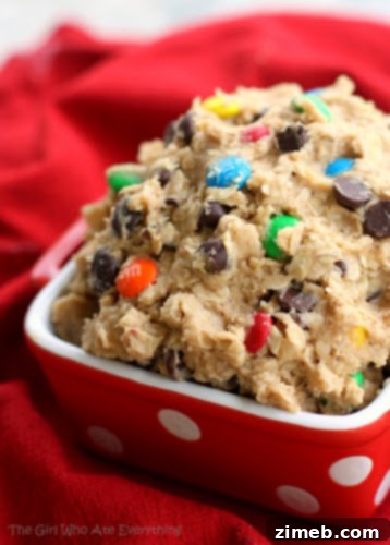 A tempting Monster Cookie Dough Dip in a bowl, surrounded by dippers like graham crackers and pretzels, showcasing its irresistible texture.
