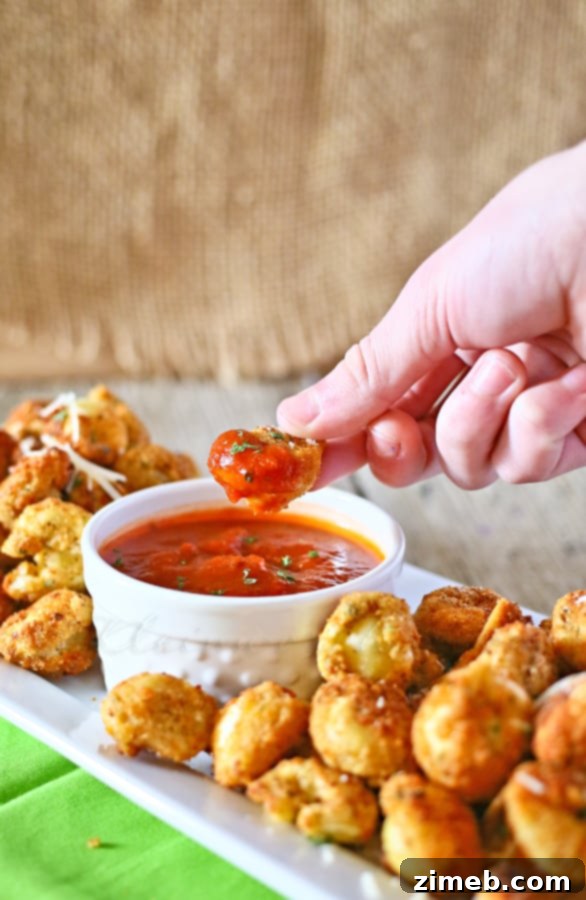Crispy Deep Fried Tortellini, golden brown and served with a side of marinara sauce, perfect for dipping.