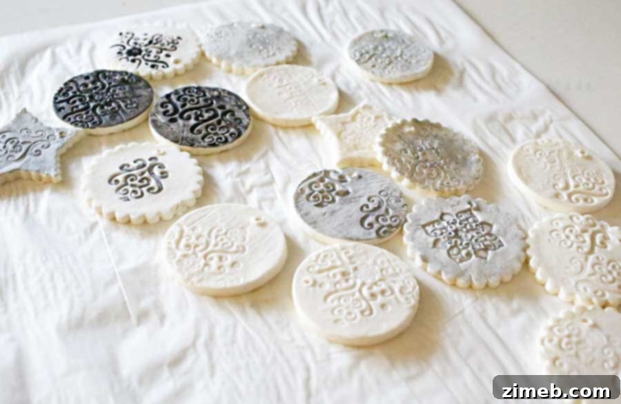 Several finished Stamped Clay Ornaments, painted and sealed with Mod Podge Pearl, showcasing their iridescent shimmer and readiness for tree display.
