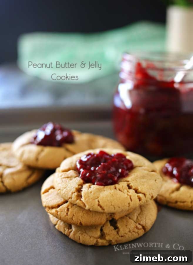 Stack of Peanut Butter & Jelly Cookies, each with a vibrant dollop of blackberry jam, ready to be enjoyed.