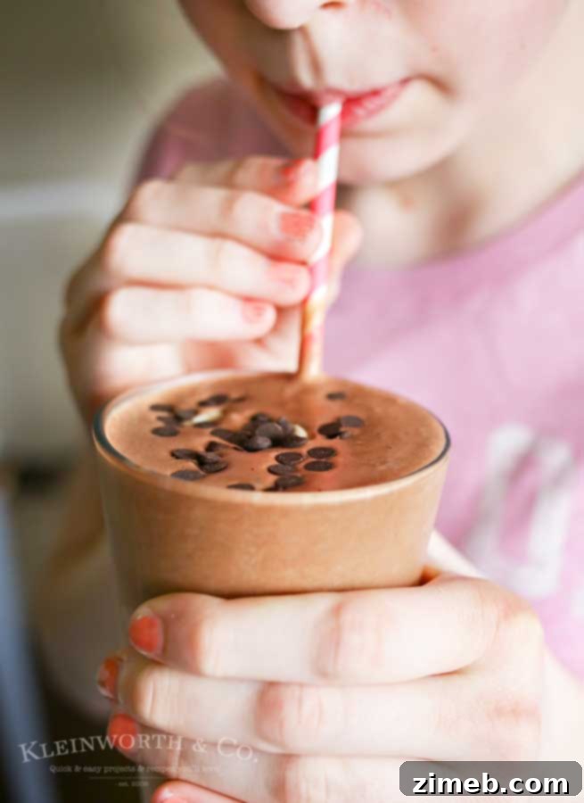 Decadent Chocolate Banana Smoothie 7 Delicious Chocolate Banana Smoothie topped with fresh banana slices and mini chocolate chips, a delightful and satisfying treat for any time of day.