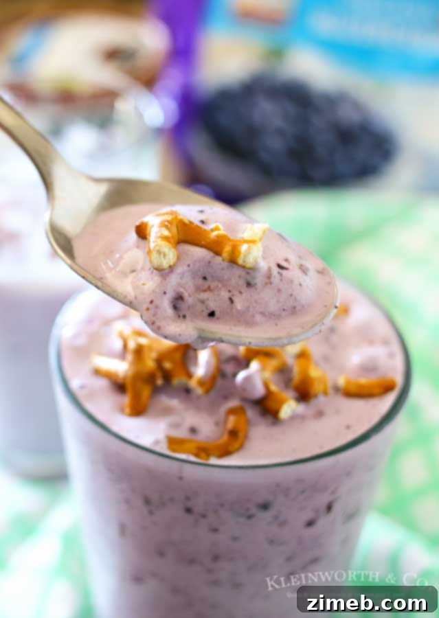 Vegan Blueberry Coconut Shake 4 A person holding a glass of Blueberry Coconut Shake, enjoying a healthy snack.