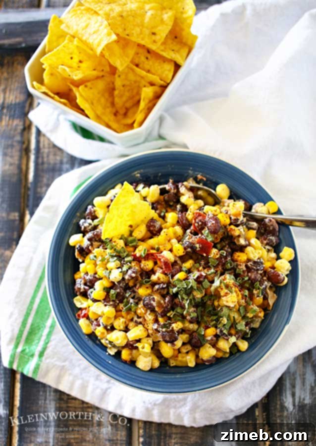 Street Corn Salsa 2 Close-up of Mexican Corn Salsa in a white bowl, showcasing the colorful corn, black beans, red peppers, and green chives, ready to be served.