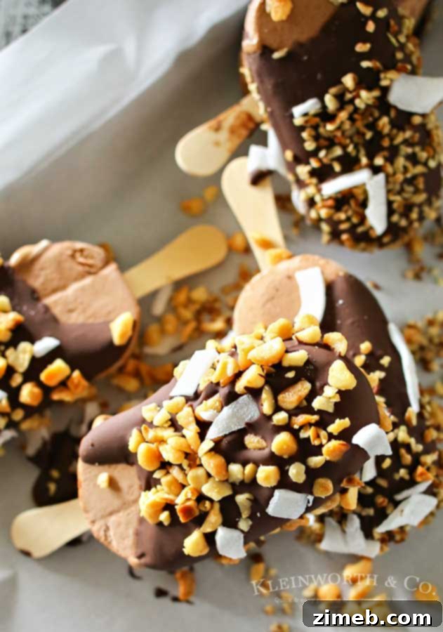 Hand sprinkling chopped macadamia nuts and coconut onto a chocolate-coated ice cream bar.