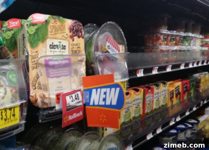 Sip and Savor: Vanilla Coconut Black Tea and Elevate Organic Salads 9 A person's hand reaching for an organic elevĀte salad in the refrigerated produce section of a Walmart store.