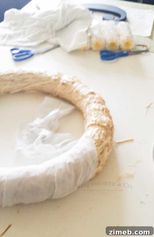 Tropical Plumeria Wreath 4 Detailed view of a Plumeria Wreath in progress, showing the fabric-wrapped base and beginning of flower placement.