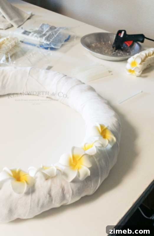 Tropical Plumeria Wreath 5 Wreath base fully covered with white fabric strips, ready for foam plumeria flower attachment in this DIY tutorial.