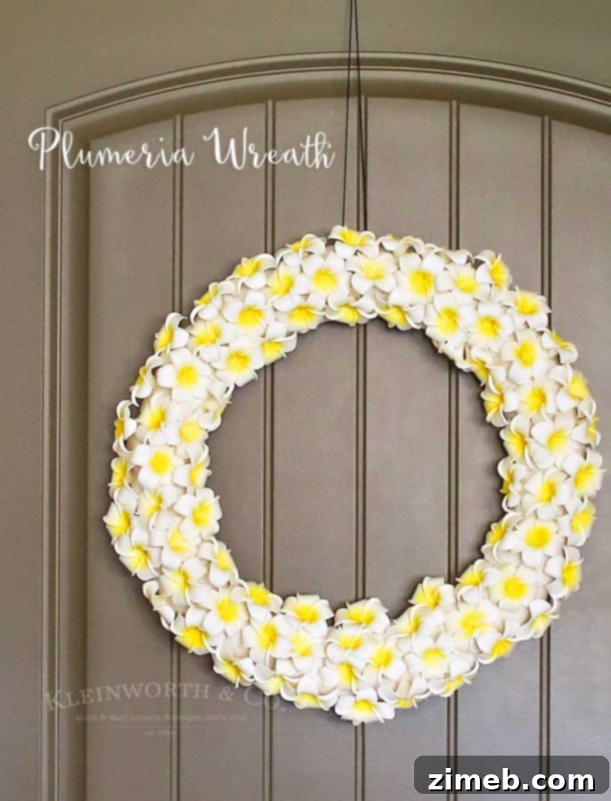 Tropical Plumeria Wreath 7 Completed Plumeria Wreath proudly displayed on a door, showcasing a beautiful and easy summer DIY decoration.