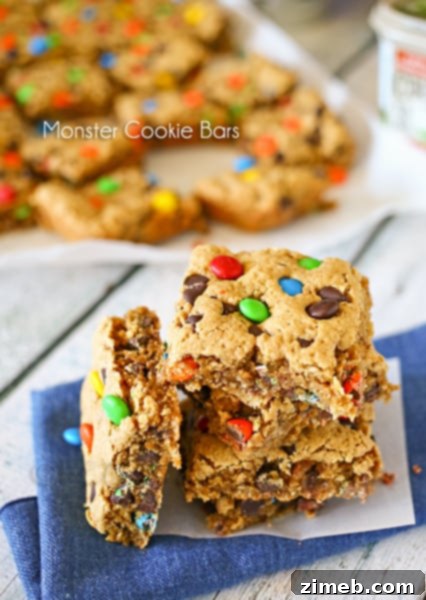 A plate of Monster Cookie Bars, packed with chocolate chips, M&M's, and oats.
