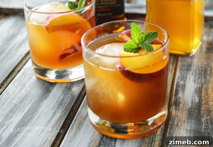 Peachwood Palmer 3 A refreshing Peach Bourbon Arnold Palmer cocktail with a slice of fresh peach, ideal for summer sipping.