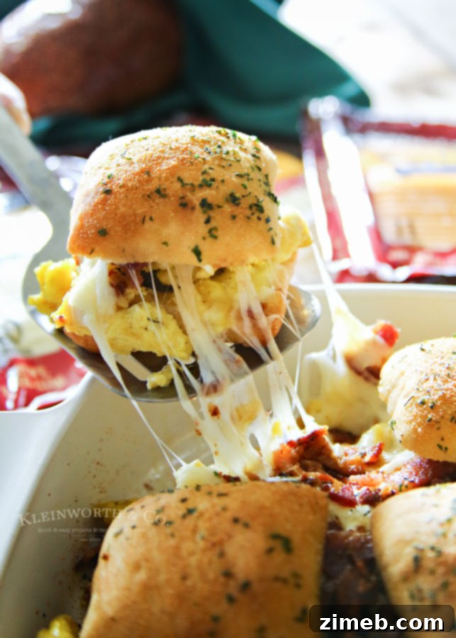 Ultimate Breakfast Sliders 2 Close-up of baked Sausage Egg Bacon Cheese Breakfast Sliders, showing melted cheese and golden buns.