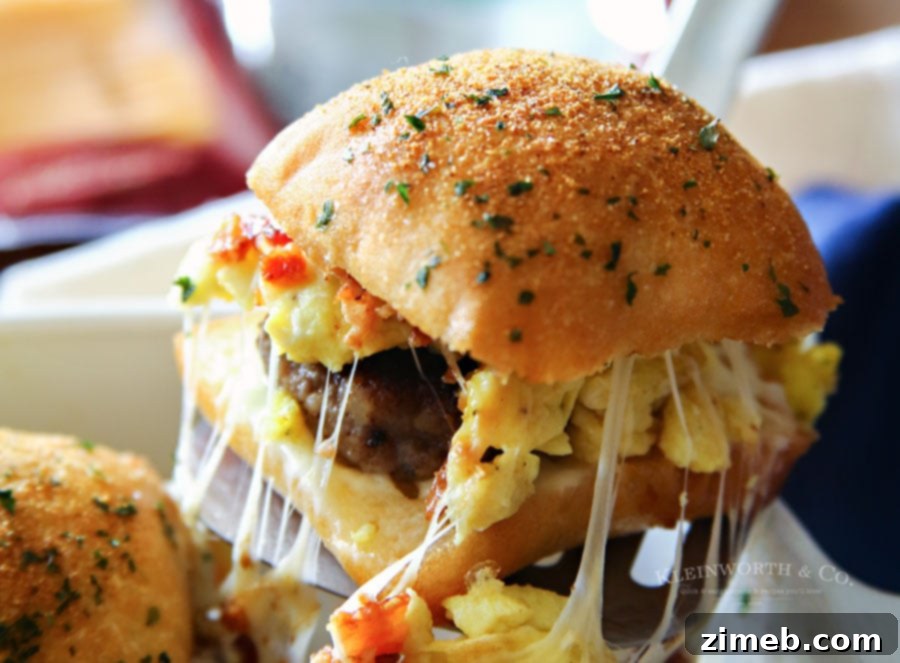 Ultimate Breakfast Sliders 5 Assembled Sausage Egg Bacon Cheese Breakfast Sliders ready for baking.
