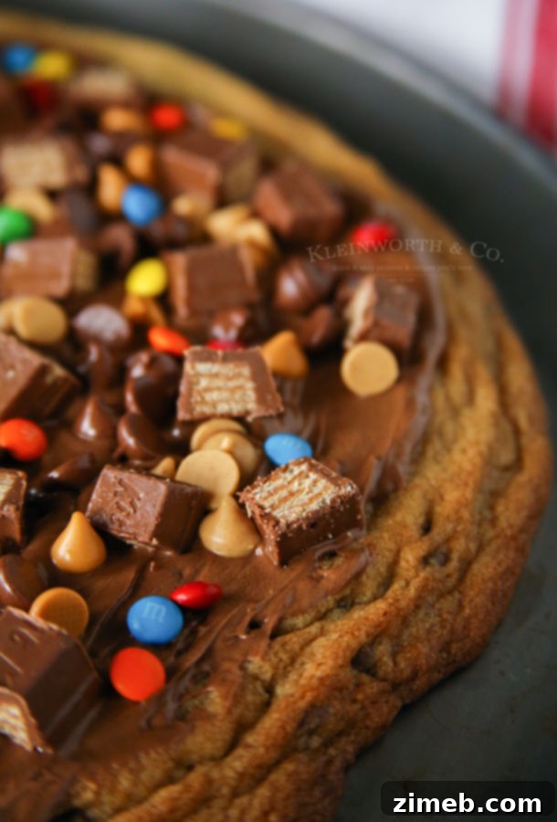 Ultimate Chocolate Chip Cookie Pizza 4 Four perfectly cut slices of Loaded Chocolate Chip Cookie Pizza arranged on a plate, highlighting the thick, chewy cookie and the generous, colorful toppings.