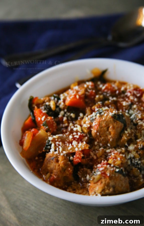 A rustic bowl of Italian Wedding Soup, garnished with fresh parmesan cheese and a sprinkle of herbs.