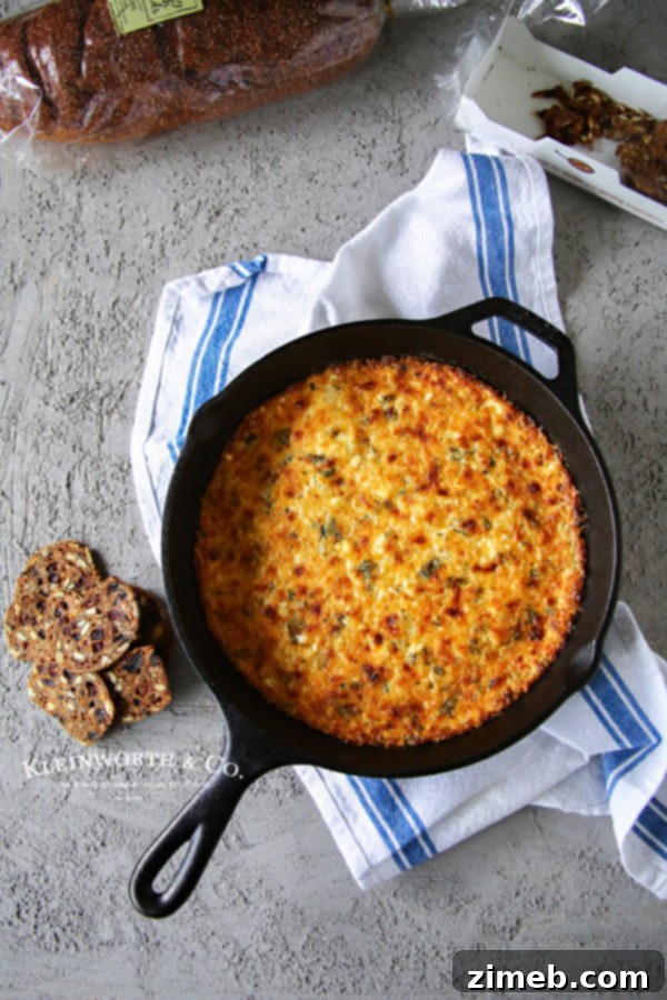 Velvety Hot Havarti Spinach Dip 2 Close-up of baked Cheesy Havarti Hot Spinach Dip in a skillet, bubbling and golden brown.