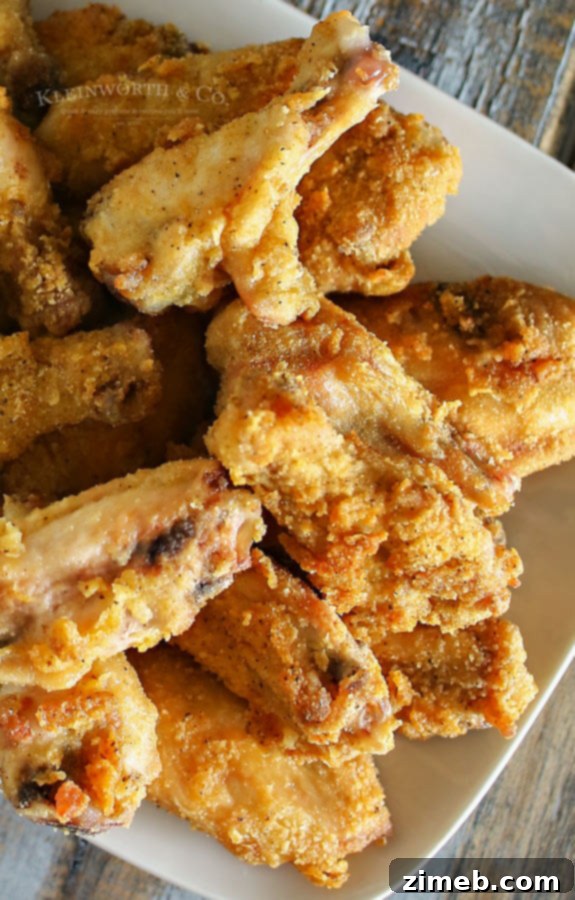 Golden Crisp Flavor Wings 2 A close-up of a stack of golden-brown Crispy Seasoned Chicken Wings on a plate, showing the texture and seasoning.