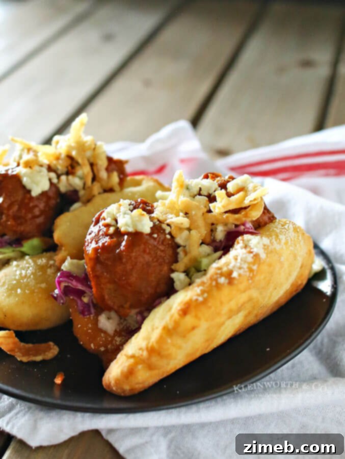 Signature BBQ Meatball Fry Bread Tacos 2 Close-up of a BBQ Meatball Fry Bread Taco, showing the juicy meatballs, fresh cabbage, and blue cheese crumbles on golden fry bread.