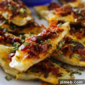 Close-up of golden-brown potato wedges, seasoned and baked to perfection, arranged on a plate, topped with cheese, crispy bacon pieces, and green onions.