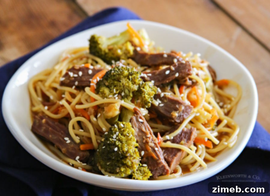 Close-up of Slow Cooker Beef Teriyaki Lo Mein served with noodles.