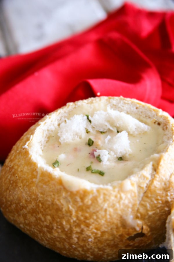 Freshly hollowed sourdough bread bowl with a side of clam chowder, ready to be filled.