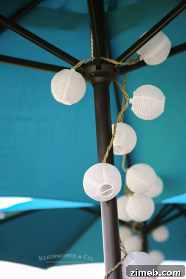 Hanging string lights illuminating the Spring Outdoor Pallet Table Decor at dusk.