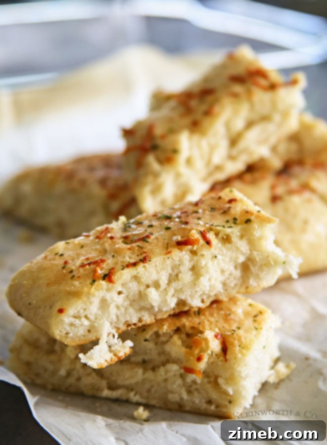 Close-up of freshly baked Easy Garlic Parmesan Breadsticks, showing the golden brown crust and savory toppings.