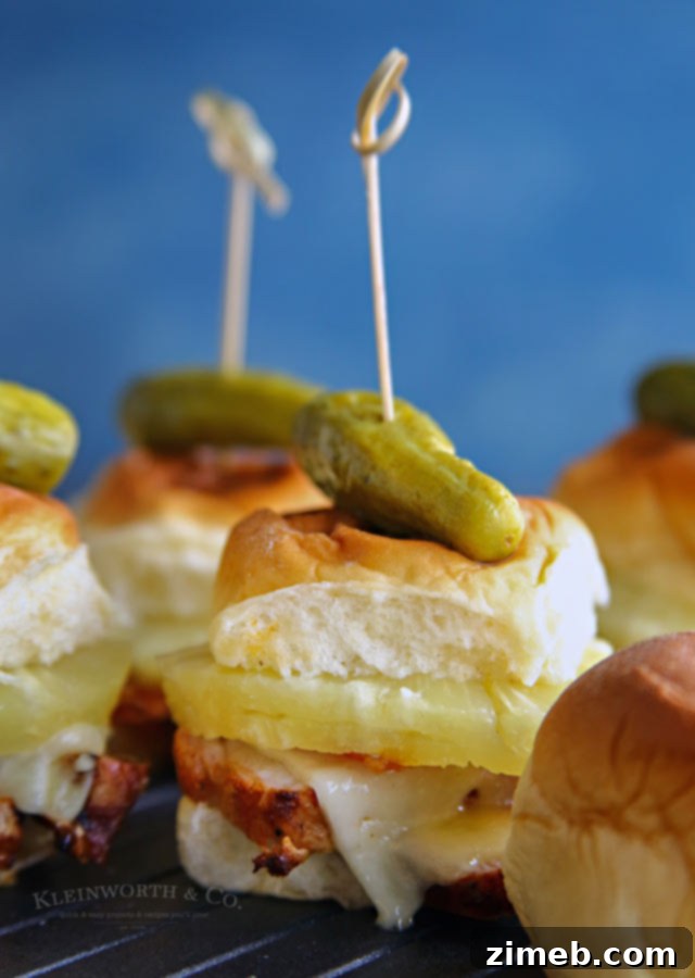Aloha Pork & Havarti Melts 3 Close-up of a stack of Hawaiian Havarti Pork Sliders with grilled pineapple and bacon, ready to serve.