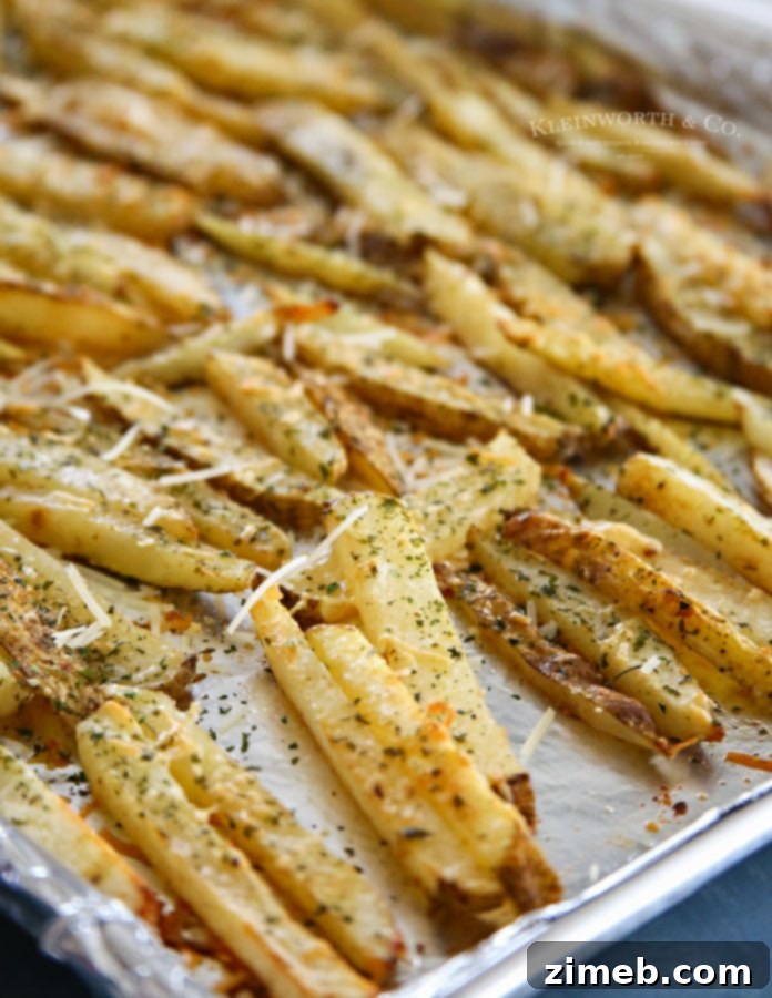 Ultimate Garlic Parmesan Baked Steak Fries 3 Close-up of golden-brown Garlic Parmesan Baked Steak Fries with fresh parsley garnish, showcasing their crispy texture.
