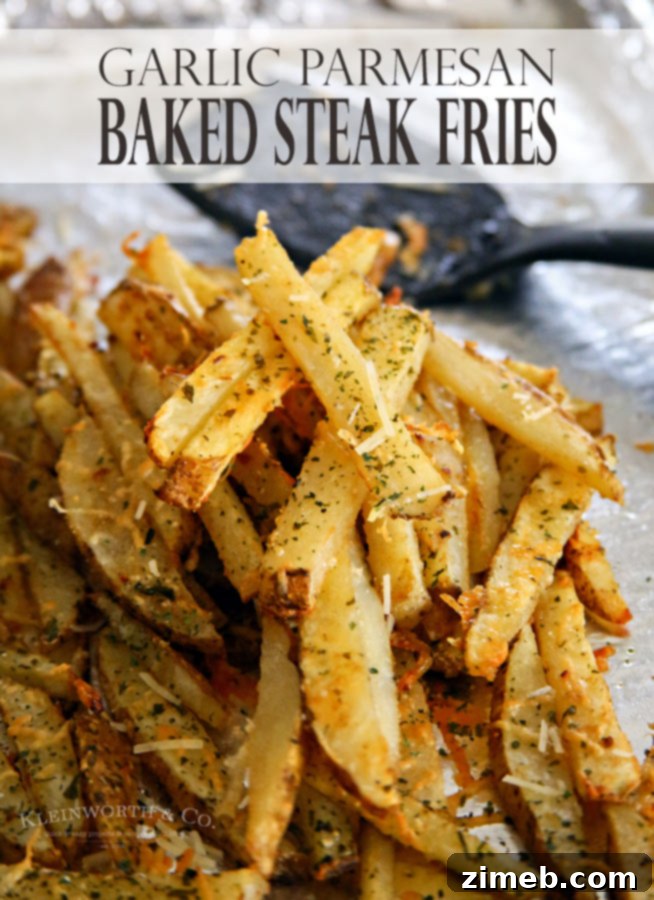 Ultimate Garlic Parmesan Baked Steak Fries 9 A large pile of golden-brown Garlic Parmesan Baked Steak Fries, sprinkled with fresh green herbs.