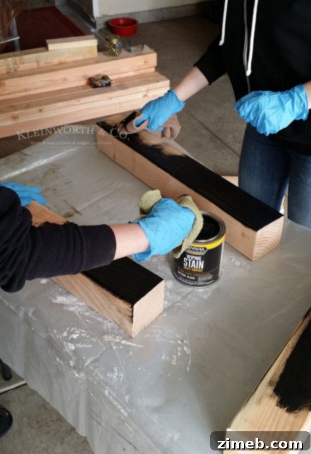 Staining legs of DIY Pallet Outdoor Dining Table