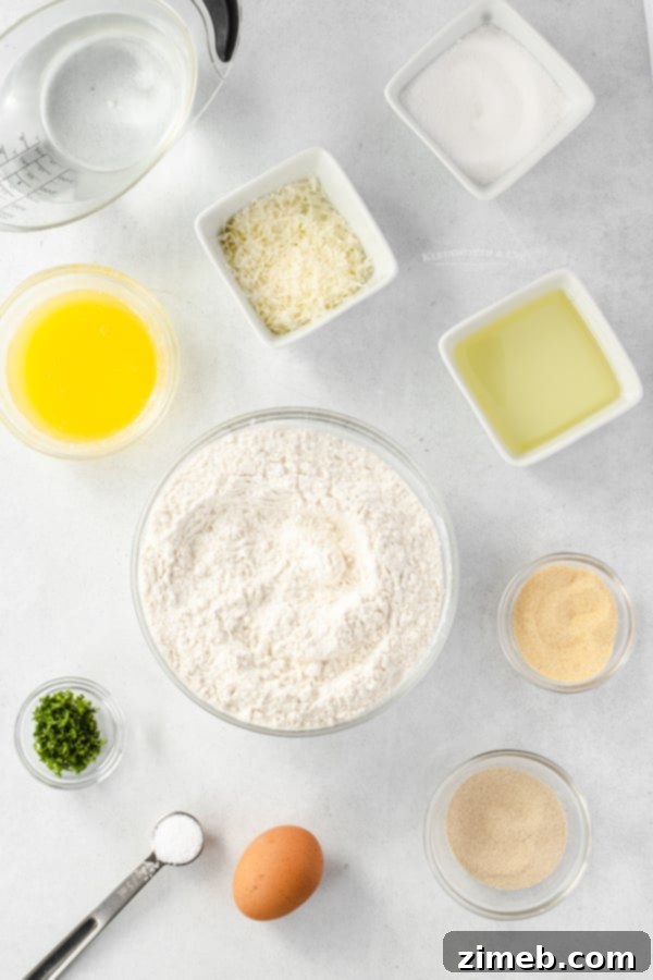 Garlic Parmesan Dinner Rolls in 30 Minutes 6 A selection of essential ingredients for 30-Minute Garlic Parmesan Dinner Rolls including flour, yeast, oil, and cheese.