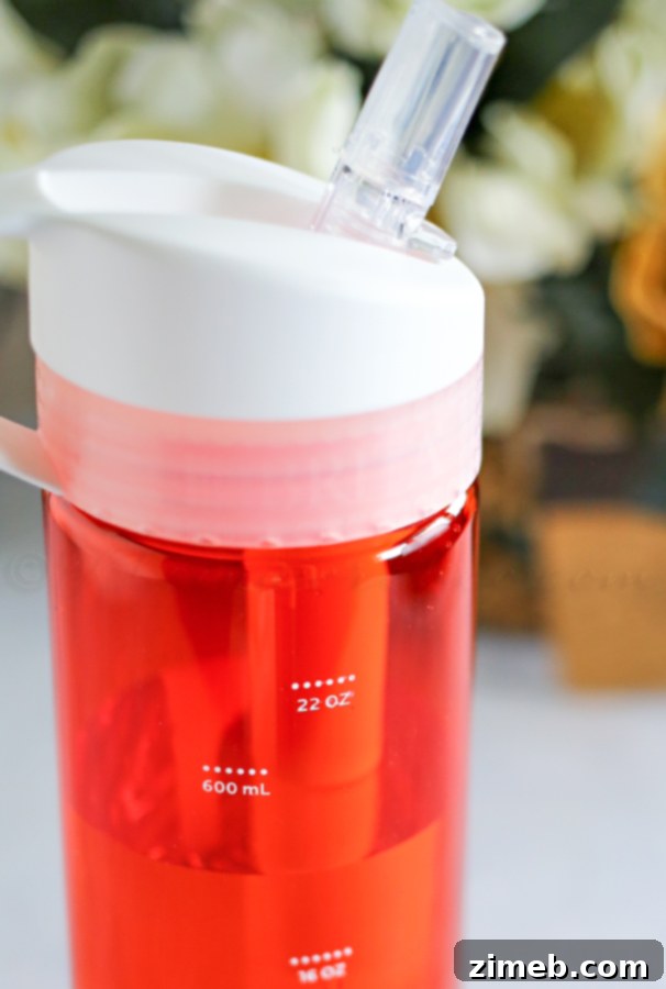 Person reaching for a bottle of water next to ZonePerfect bars, highlighting hydration