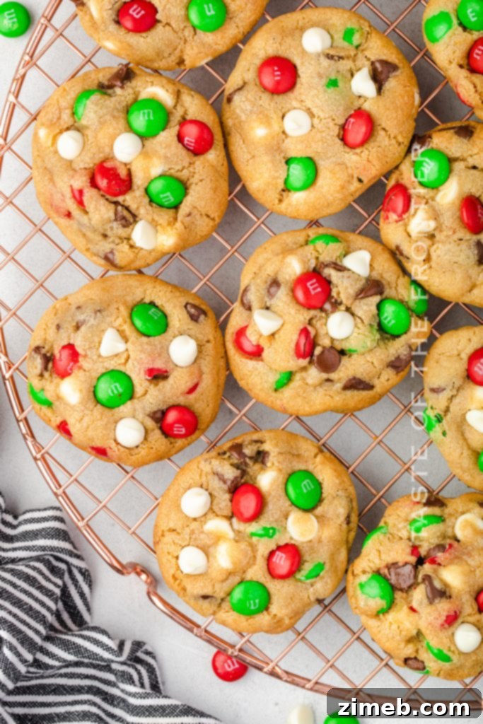 A festive close-up of Santa’s Favorite Chocolate Chip Cookies with Christmas M&Ms and white chocolate chips.