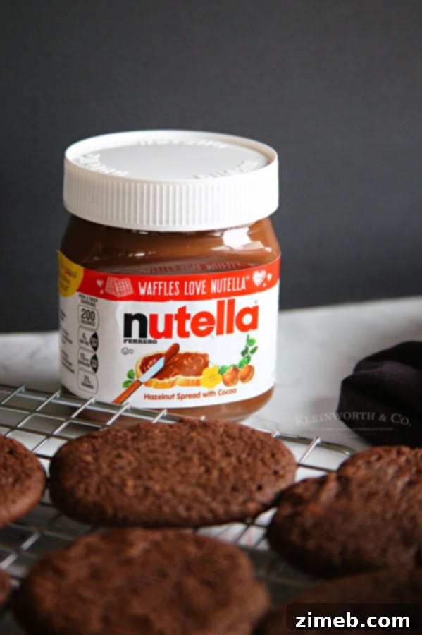 Chocolate holiday cookies topped with Nutella spread and green pistachios, ready for serving.