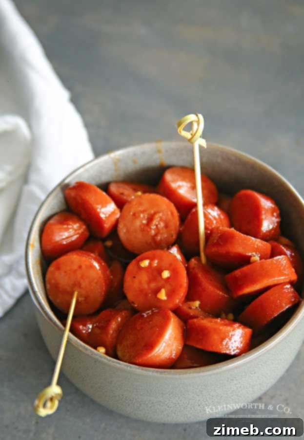Sticky Sweet and Spicy Slow Cooker Sausage 6 An overhead shot of Slow Cooker Sweet & Spicy Sausage in a white bowl, with football-themed decorations for a game day.