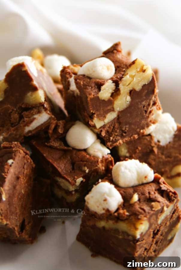 Hand scooping Rocky Road Fudge into a pan, showcasing the simple preparation process