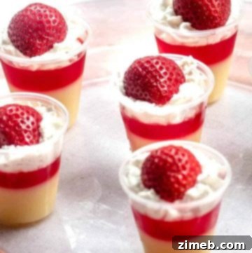 Layered Strawberry Shortcake Jello Shots with whipped cream