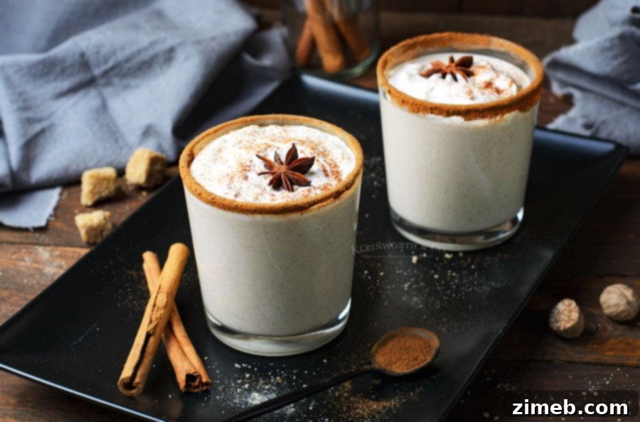 Timeless Homemade Eggnog 11 Creamy eggnog with bourbon, garnished with a cinnamon stick and fresh nutmeg, served in a classic glass for a comforting holiday beverage.