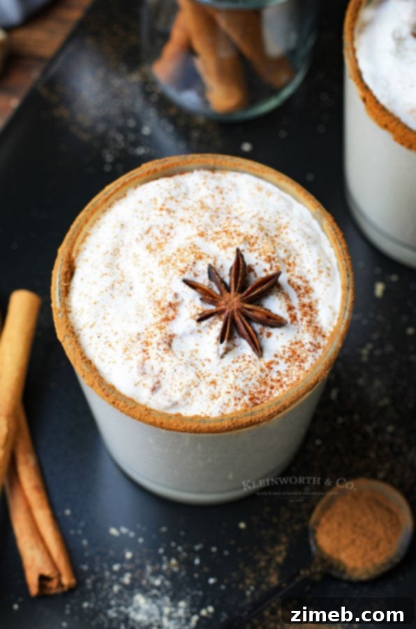 Timeless Homemade Eggnog 23 A beautifully garnished glass of eggnog, a quintessential Christmas drink, topped with whipped cream and a sprinkle of cinnamon, ready for festive gatherings.