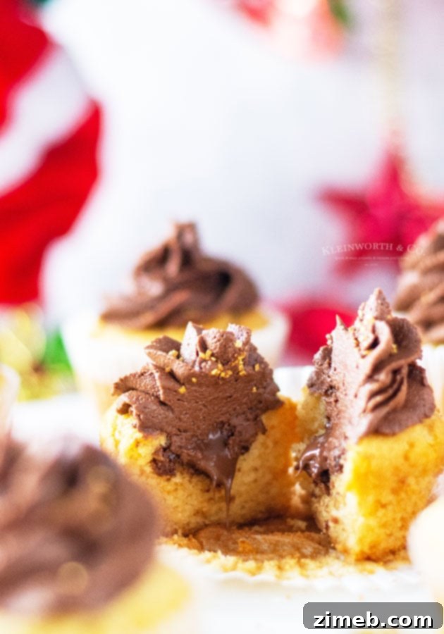 A tray of freshly baked cupcakes, some filled with Nutella and frosted.