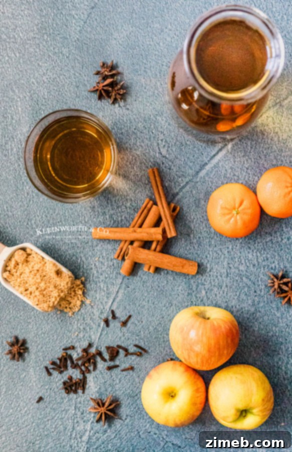 Golden Bourbon Apple Brew 4 Fresh ingredients laid out for Bourbon Apple Cider: apples, clementines, cinnamon sticks, and cloves.