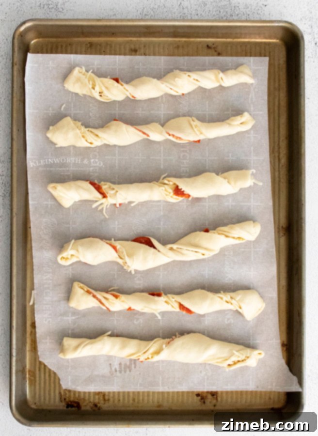 Pepperoni Pizza Bites 8 Pepperoni Pizza Dippers twisted and arranged on parchment paper, ready to go into the oven