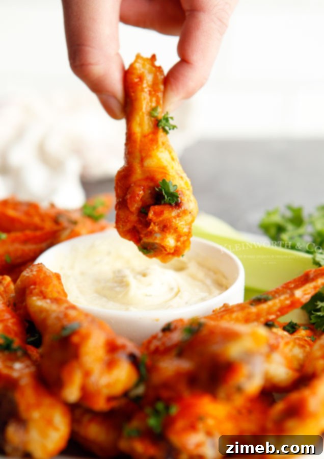 Ultimate Buffalo Wings 16 Dipping a buffalo chicken wing into blue cheese dressing.