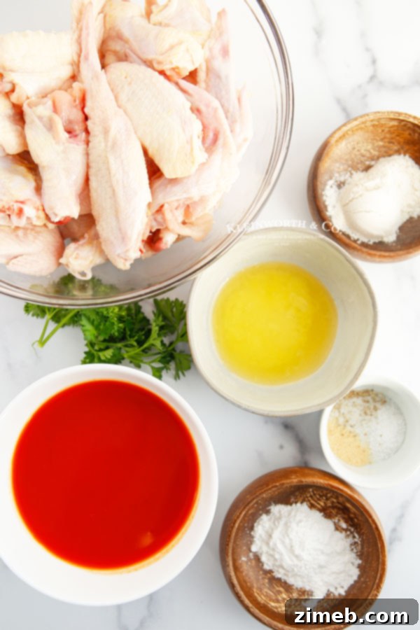 Ultimate Buffalo Wings 6 Ingredients for Buffalo Chicken Wings laid out on a cutting board.