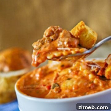 A pot of Tuscan ravioli soup, filled with hearty ingredients like large cheese-filled ravioli, fresh spinach, tomatoes, and a savory broth. The soup is rich and colorful, showcasing a delicious mix of greens and pasta in a flavorful tomato-based broth. It looks warm and comforting, perfect for a cozy meal.